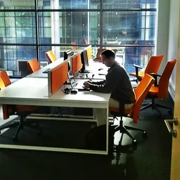 Arbeit am Schreibtisch im eCreative-Büro, draußen ein gläsernes Bürogebäude